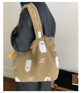 Borsa tote in peluche marrone con motivo a orso polare indossata da modella di lato