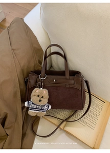 Dettaglio di borsa in pelle testa di moro con ciondolo a orsetto e texture retrò