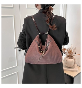 Detail of dark brown faux suede backpack with glossy straps and gold buckles