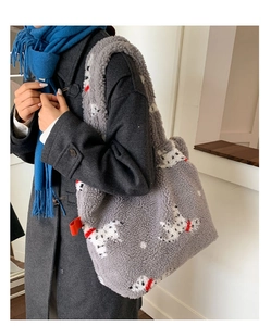 Dettaglio della borsa tote in pile grigio con stampa di cucciolo indossata a spalla