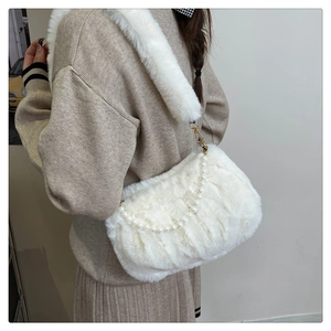 Détail du sac à bandoulière blanc en fausse fourrure avec chaîne de perles et large sangle