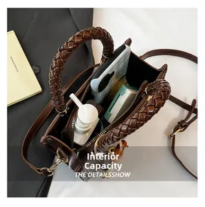 Macro shot showing internal capacity and leather weave detail of dark brown handbag