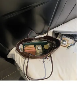 Top view of spacious brown leather tote bag interior with everyday essentials