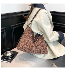 Macro detail of leopard print tote bag with brown leather drawstring and brass buckle