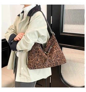 Fashionable leopard print oversized hobo bag with dark brown leather straps on a model