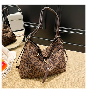 Detail of leopard print hobo bag with dark brown leather straps and gold hardware