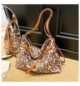 Detailed mirror reflection view of leopard print shoulder bag with brown leather straps