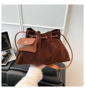 Detail of dark brown suede bucket bag with pleated design and hanging leather pouch