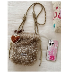 Detail der Plüschtasche mit Rehkitzmuster, gewebtem Seilgurt und Herzanhänger-Accessoire