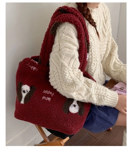 Dettaglio della borsa tote in pile orsetto rosso con ricamo a cane e texture soffice