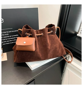 Close-up of brown suede drawstring bucket bag with a small detachable leather pouch