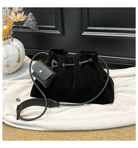 Detail of black suede bucket bag featuring pleated texture and a detachable mini pouch