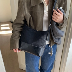 Detail of black tote bag showing high-quality suede and smooth leather patchwork texture