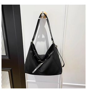 Detailed view of black nylon hobo shoulder bag with adjustable strap and gold hardware