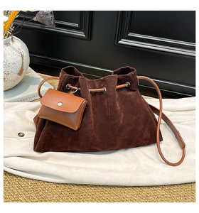Detail of dark brown suede bucket bag with drawstring closure and leather pouch