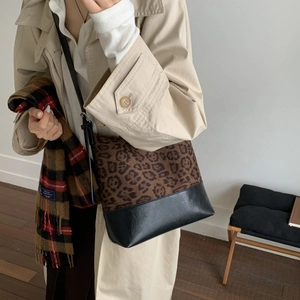 Detailed view of leopard print tote bag paired with an autumn trench coat and scarf