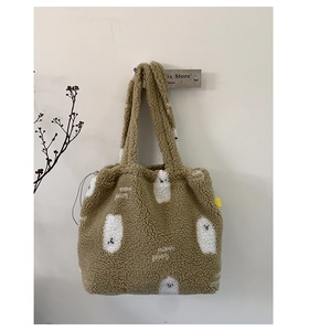 Dettaglio della borsa tote marrone in pile con ricamo a forma di fantasma bianco