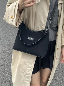 Black canvas crossbody bag with adjustable strap and shoulder handle for casual wear
