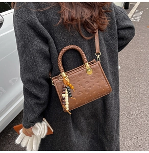 Brown retro crossbody bag with embossed puppy patterns and colorful beaded charm