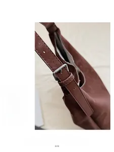 Close-up of the vintage brown leather shoulder strap with a silver adjustable buckle
