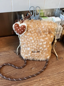 Plüsch-Beuteltasche mit Hirschmuster, geflochtenem Riemen und Herzanhänger auf Holz