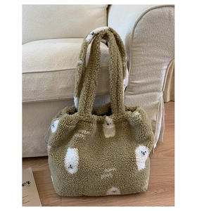Dettaglio della borsa tote in sherpa verde oliva con motivi di animali bianchi
