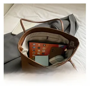 Interior view showing the large capacity and storage pockets of this brown leather tote bag