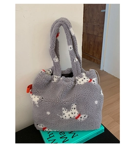 Dettaglio della borsa tote in pile grigio con motivi dalmata appoggiata su un libro