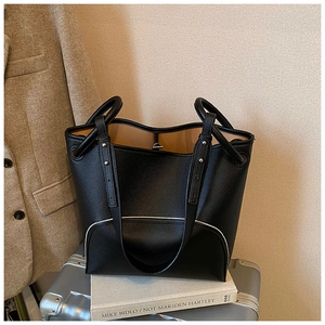 Detail of black lychee grain leather bucket bag showing silver zipper and soft texture