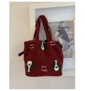 Dettaglio della borsa tote in pile bordeaux con ricamo a cucciolo e texture soffice