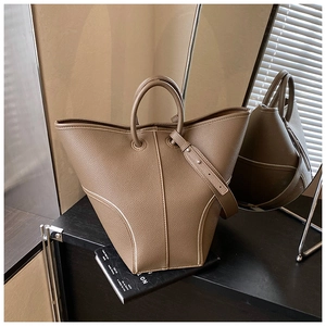 Detail shot of khaki brown lychee grain leather bucket bag with white contrast stitching