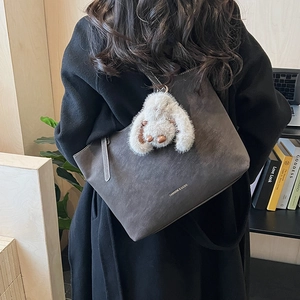 Detail der dunkelgrauen Tragetasche mit Plüschhasen-Anhänger und Fashion & Bags Schriftzug