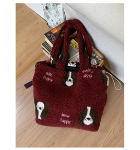Dettaglio della borsa tote bordeaux in peluche con ricamo di cucciolo e texture soffice