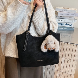 Details der schwarzen matten Shopper Tasche mit Kontrastnaht und Plüschhasen-Anhänger