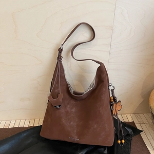 Detail of dark brown matte leather hobo bag with floral charm and Coih 2dn logo