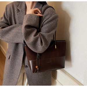 Detail of suede and smooth leather patchwork tote bag with fashion lettering and tassel