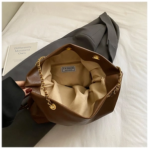 Interior view of brown leather bucket bag with gold chain strap and large capacity