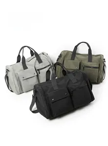 Detailed view of large gym bags in grey, olive, and black with durable nylon fabric