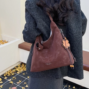 Detail of brown suede Hobo bag with flower charm and COIH-2DN LONDON logo engraving