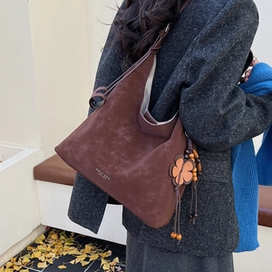 Macro detail of dark brown tote bag texture with flower charm and bead decor