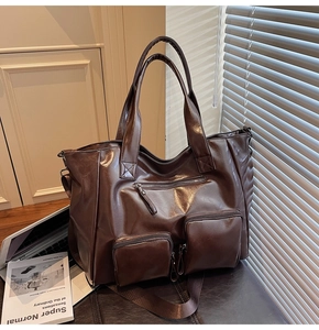 Macro view of dark brown washed PU leather tote bag with three functional front zipper pockets
