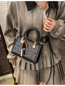 Chic black quilted handbag with cartoon dog patterns and metallic charm detail