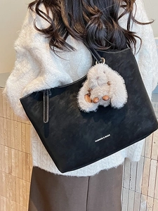 Vintage-Shopper aus schwarzem Wildleder mit weißem Plüschhasen-Anhänger und Ziernähten