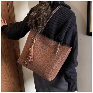 Detail of vintage leopard print tote bag with brown tassels and fine leather straps