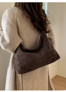 Détail du sac Hobo en daim marron foncé montrant le drapé et la texture du cuir mat