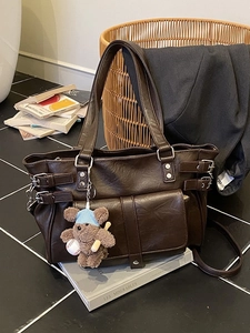 Brown vintage faux leather tote bag with metallic buckles and plush bear charm