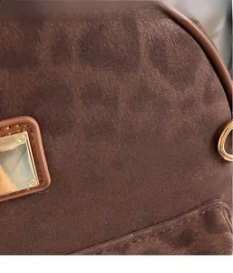 Détail du sac à dos léopard marron montrant la texture daim et les boucles dorées