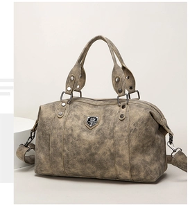 Detail of vintage grey-green PU leather tote bag with metallic logo and textured finish