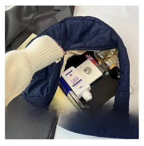 Detail of spacious heart-quilted puffer tote interior holding a tablet and cosmetics