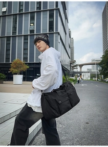Detail shot of black large capacity gym bag with side zipper pocket and adjustable strap